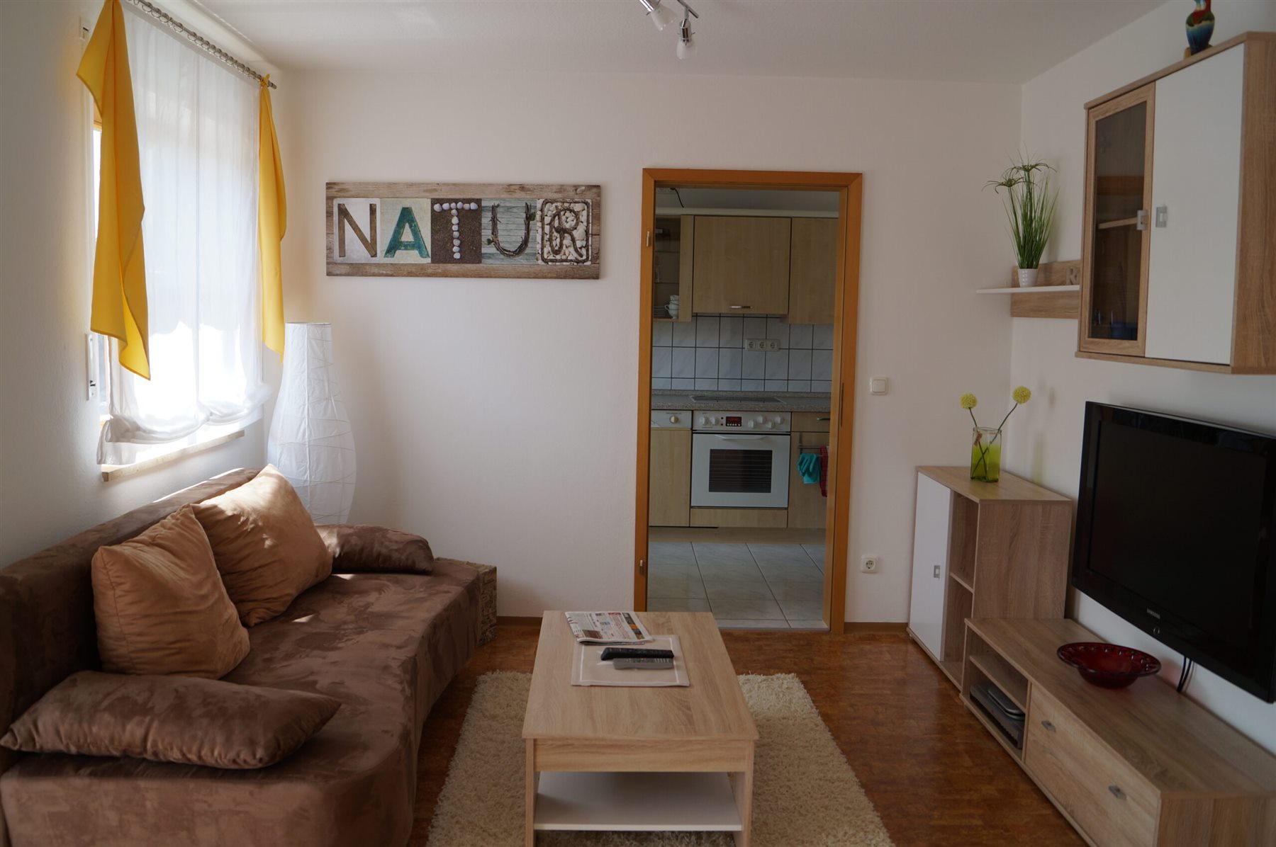 Wohnzimmer der Ferienwohnung Wagner mit Sofa und Blick zur Küche